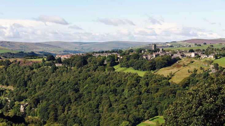 A wide view of the Hardcastle Crags landscape showing wooded valleys, hills and fields